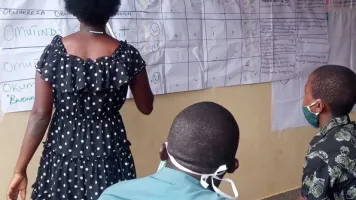 Women presenting score card findings to stake holders during a CVA meeting at Kaziba health center II, Kamwenge. World Vision