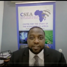 Screenshot of video: Speaker in front of panel sign for CSEA.